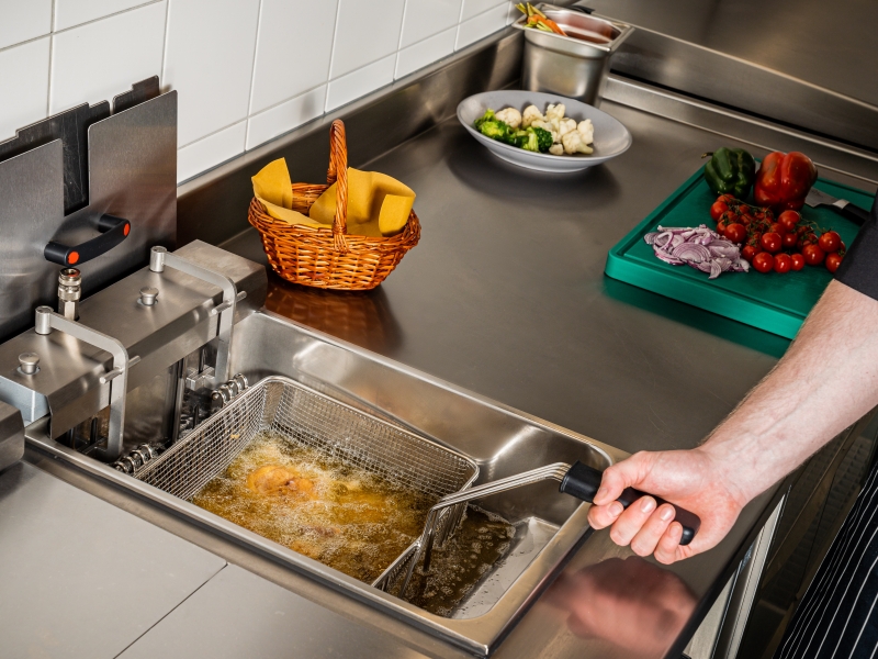 In CNS-Arbeitsfläche integrierte Fritteuse beim Schnitzel frittieren