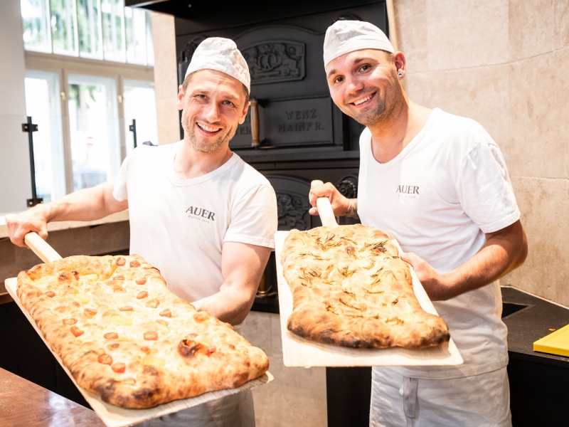 Zwei Bäcker von Martin Auers Team im Schillerhof mit frisch Gebackenem