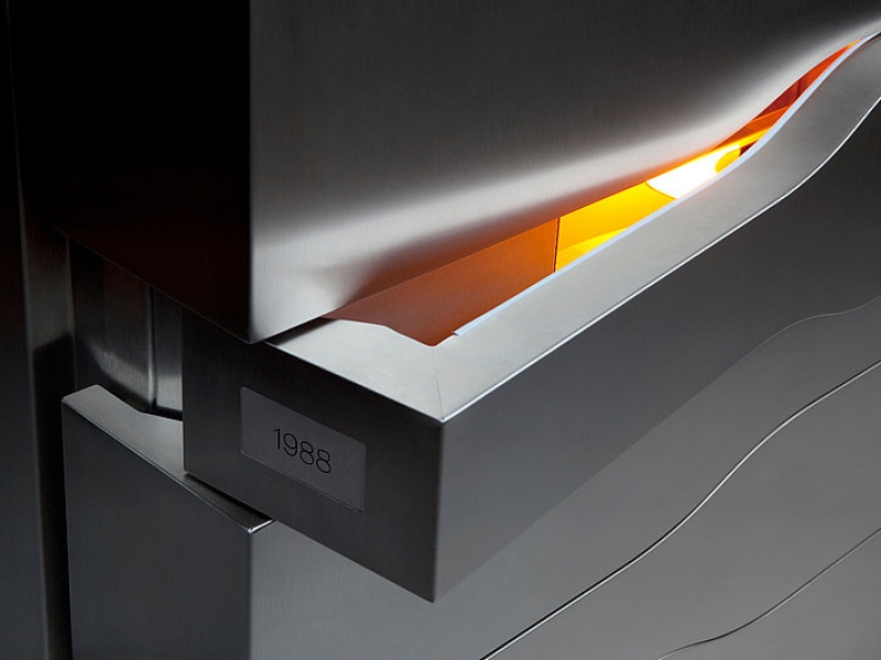 Detail-Aufnahme von sich öffnendem Edelstahl-Flügel zu Lagerfläche von Veuve Cliquot Markenflasche mit Jahrgang 1988