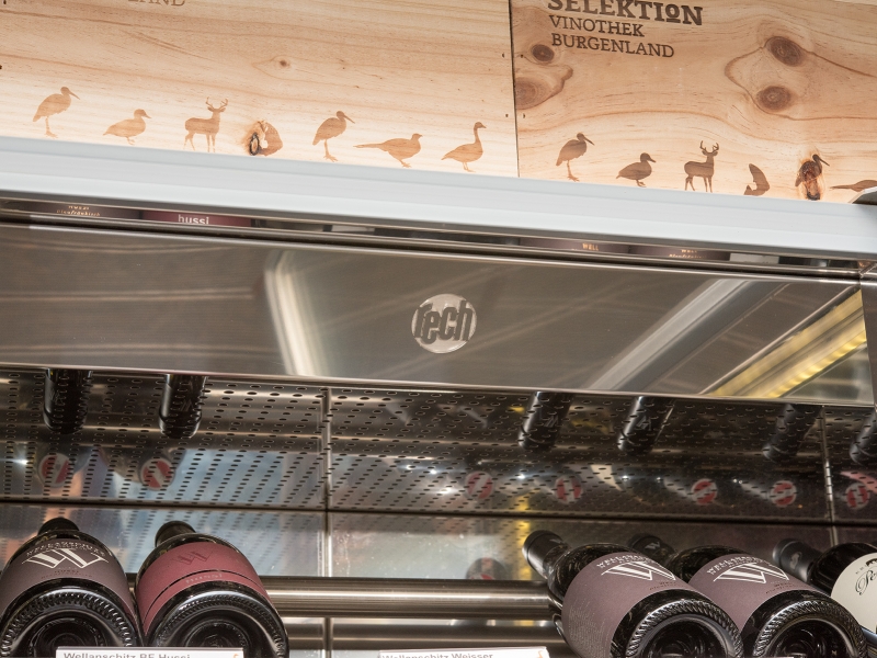 Detail-Aufnahme der Kühlvitrine mit darin gelagerten Weinflaschen