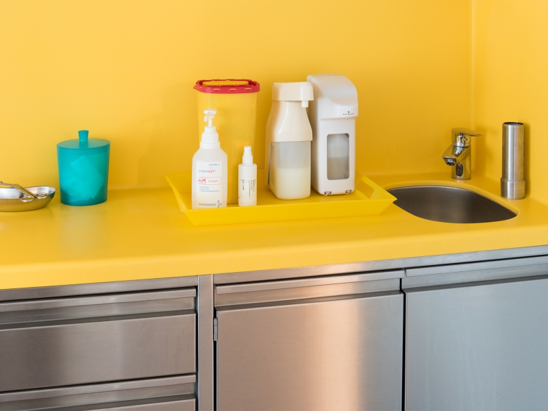 Gelbe Corian-Platte mit fugenlosem Wandhochzug und von unten angebrachtem Edelstahlbecken auf Niro-Unterbau