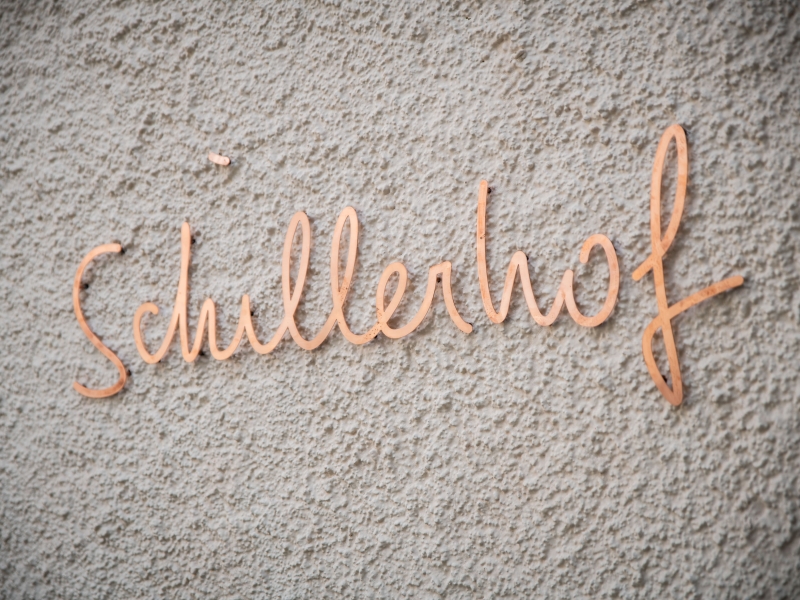 "Schillerhof"-Schriftzug in Kupfer ausgeführt auf Fassade angebracht