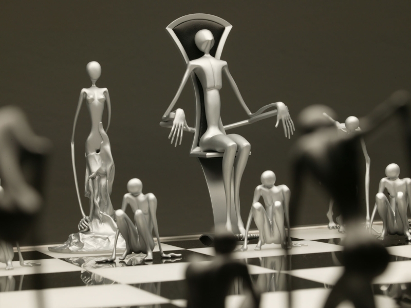 Detailaufnahme: Metallische Schachfiguren in künstlerischer Form auf Schachtisch in Edelstahl